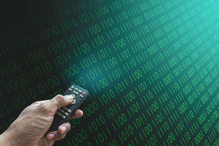 A male programmer hand is pressing a remote control to control a computer in a hacked password on...