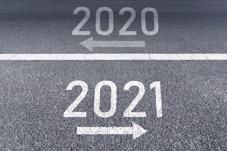 The sign arrow back to the 2020 year and go ahead 2021 Written on The asphalt road background The...