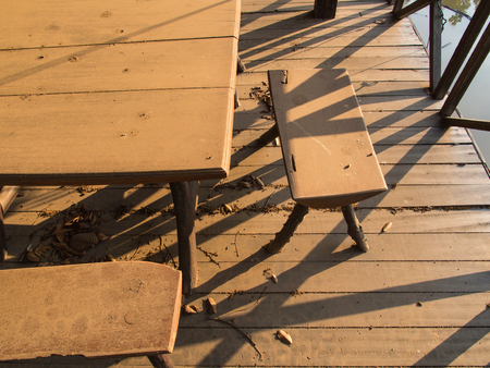 The Desk and Chair on a Wooden Floor with Leaves in Abandoned Restaurantの写真素材