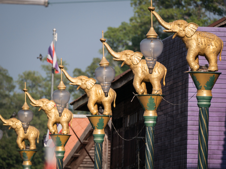 The Golden Fighting Elephants Statue on Top of The Pillar in The Purple Town , Uthathani Province Thailandの写真素材