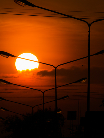 The Power Lamp Poles behind The Sun and Clouds  in The Morningの写真素材