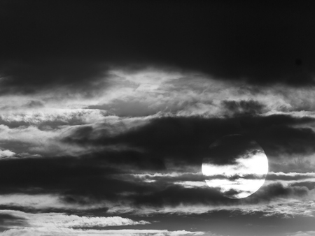 The Sun behind The Fluffy Gray Clouds