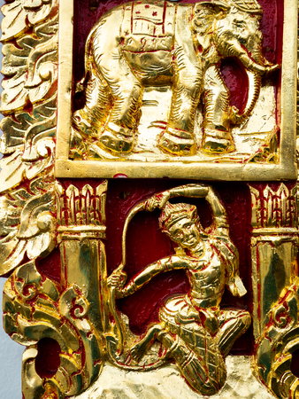 The Golden Fairy and Elephant Sculpture in Red Background at The Wall of Templeの写真素材