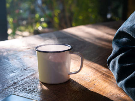 The Water Vapor on Top of  The Coffee Cup beside The Man Arm Wearing a Jean Jacketの写真素材