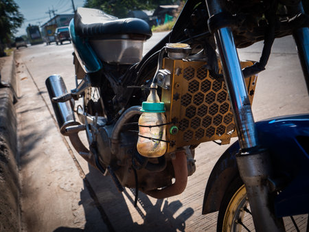 The Milk Bottle is Used as a Modified Device That Contains Water to Cool The Radiator in Motorbike in The Streetの写真素材