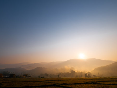 During The Winter of The Rice Fields behind The Sunrise and Fog on The Mountainの写真素材