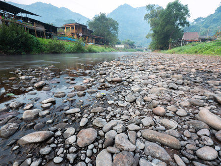The Water Flows Strong Through The Rocks in The Clear Water Stream in The Morningの写真素材