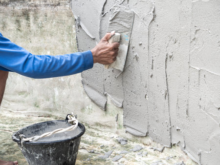 The worker was plastering the wall at daytimeの写真素材