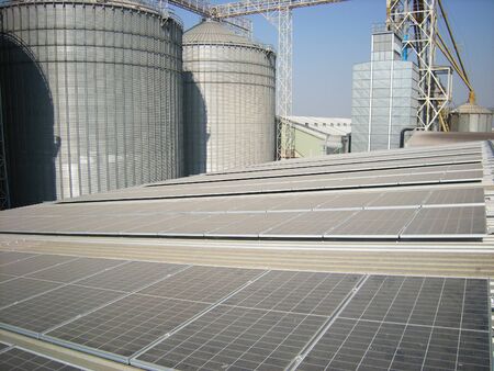 Dusty Solar Panel with Silo Backgroundの写真素材