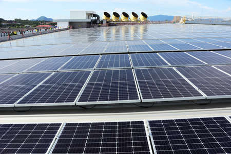 Solar PV System on Industry Roof with Cooling Towers Backgroundの写真素材