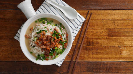 Porridge with spiced pork porridge Garnish with spring onions, coriander, sauteed cabbage, and fried...