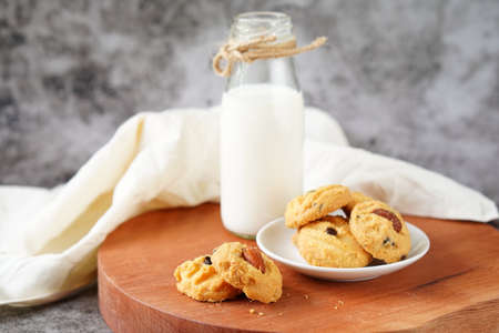 Fresh milk in a glass and almond cookies on the dining table