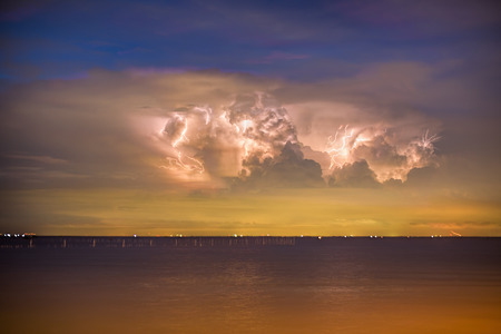 lightening over the rain storm cloud above the sea during twilight