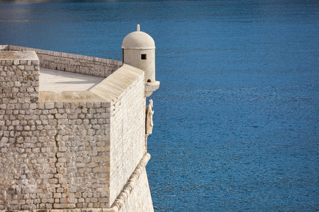 Watchtower on the stone walls above blue Adriatic sea, Dubrovnik, Croatiaの写真素材