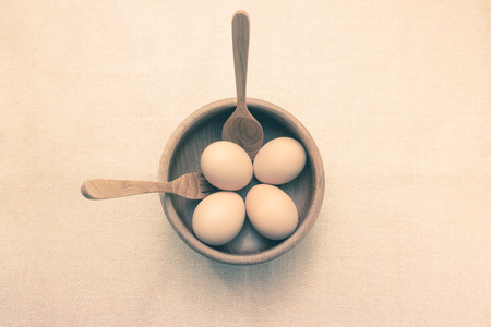 Raw Eggs in a teak bowl with teak spoon and fork ready to serveの写真素材