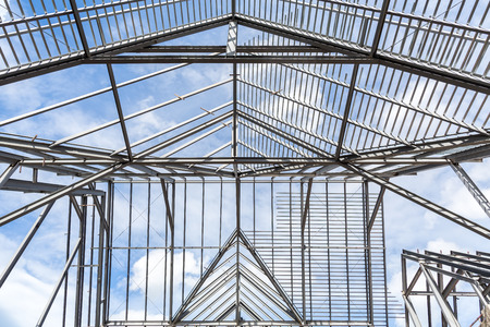 Roof frame of business building under construction against blue sky.の写真素材
