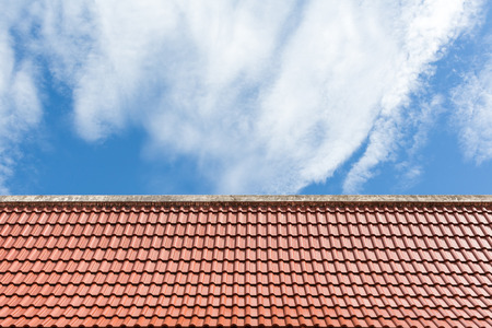 old style orange clay tiles roof top against nice blue sky.の写真素材