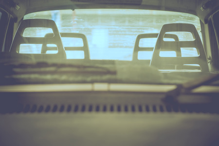 Abandon broken car looking through windshield  with selective focus on head rest of the driver seat in vintage tone.の写真素材