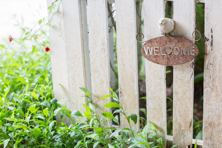 Rustic welcome sign on white wooden fence with selective focus.の写真素材