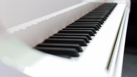 White grand piano with selective focus on the keyboard.の写真素材