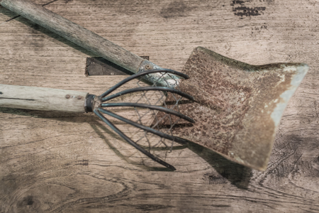 Old and rusty Shovel and lecher on top of wooden table with vintage  grunge touch and selective focus.の写真素材