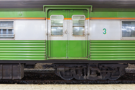 Close up of a green passenger carriage bogie on a train platform.の写真素材