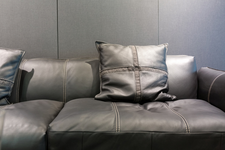 Modern style gray leather sofa and pillows in a gray living room.の写真素材