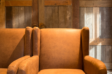 Vintage brown leather armchair in a rustic log cabin home living room.