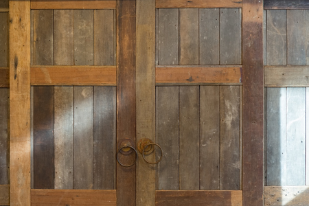 Old vintage folding wooden door frame with brass handle in countryside.の写真素材