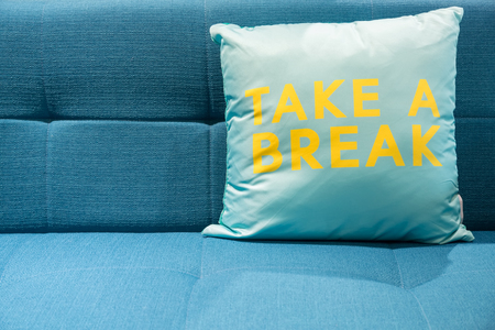 Blue fabric sofa with big soft turquoise pillow.の写真素材