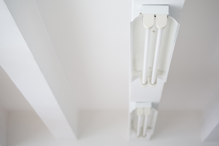 Fluorescent lights tube and rails on white ceiling office.の写真素材
