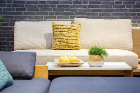 Cloth sofa and cushions with different size and color in a living room with dark gray brick wall.の写真素材