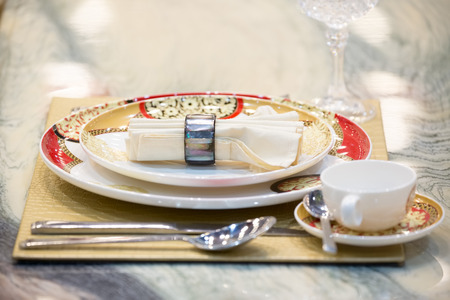 Luxury dining table setting with white plates, fork, knife and spoon with napkin on white marble table with selective focus.の写真素材