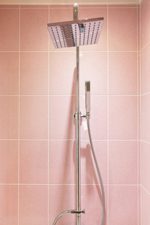 Close up of shower heads with colorful pink wall tiles.の写真素材