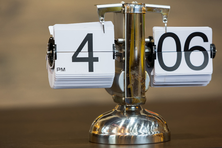 Old style silver flip clock on a wooden tableの写真素材
