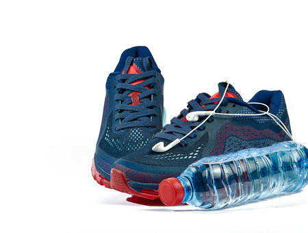 Fitness set with sneakers, bottle of water and headphones isolated on white backgroundの写真素材
