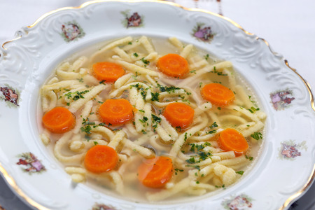 Chicken homemade noodle soup with parsley and carrotの写真素材