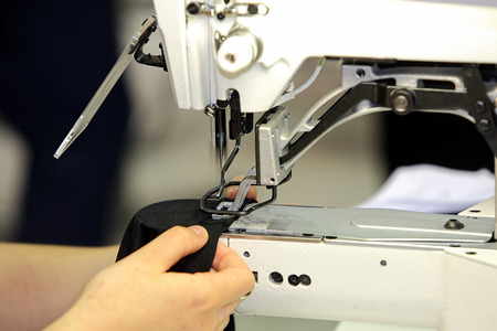 Seamstress sews material on the sewing machine