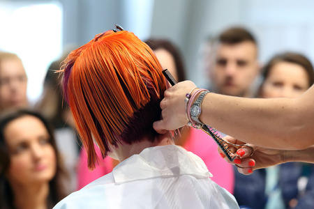 POZNAN - APRIL 18 : Hairdresser trimming red hair with scissors at The Look Beauty Vision Poznan 2015 on April 18, 2015 in Poznan, Polandのeditorial素材