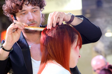 POZNAN - APRIL 18 : Hairdresser trimming red hair with scissors at The Look Beauty Vision Poznan 2015 on April 18, 2015 in Poznan, Polandのeditorial素材