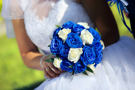 Bride with wedding blue rose bouquet outdoorsの写真素材
