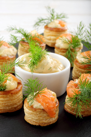 Appetizer puff pastry with dill dip and salmon on stone trayの写真素材