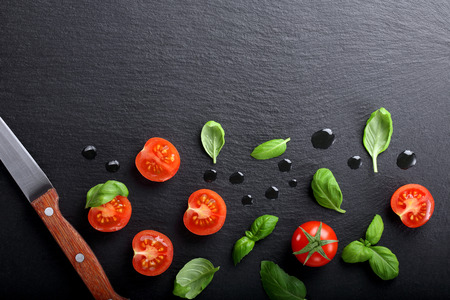 Cherry tomatoes with basil on stone background and space for textの写真素材