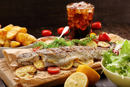 Baked fish with roasted potatoes and saladの写真素材