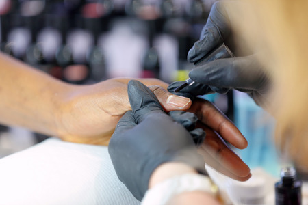 Manicurist master makes manicure on young woman handの写真素材