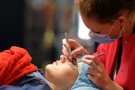 POZNAN, POLAND - MAY 07. 2016: Manicurist master makes longer eyelash at The Look Beauty Vision...