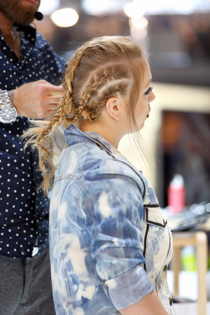 POZNAN, POLAND - MAY 07. 2016: Hairdresser arranging hairdo at The Look Beauty Vision Poznan 2016 on May 07 in Poznan, Poland.のeditorial素材