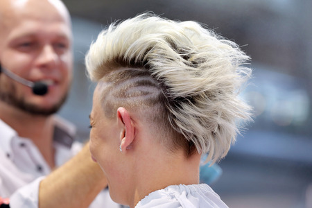 POZNAN, POLAND - MAY 07. 2016: Hairdresser arranging hairdo at The Look Beauty Vision Poznan 2016 on May 07 in Poznan, Poland.のeditorial素材
