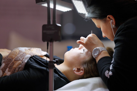 POZNAN, POLAND - MAY 07. 2016: Manicurist master makes longer eyelash at The Look Beauty Vision Poznan 2016 on May 07 in Poznan, Poland.のeditorial素材