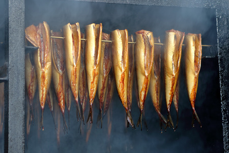 Golden smoked fish in a smokerの写真素材